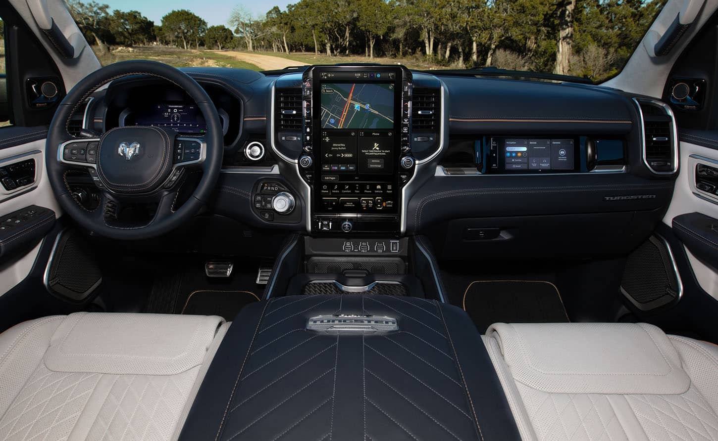 The steering wheel, Driver Information Digital Cluster, Uconnect touchscreen and front Passenger Interactive Touchscreen Display in the 2025 Ram 1500 Tungsten.
