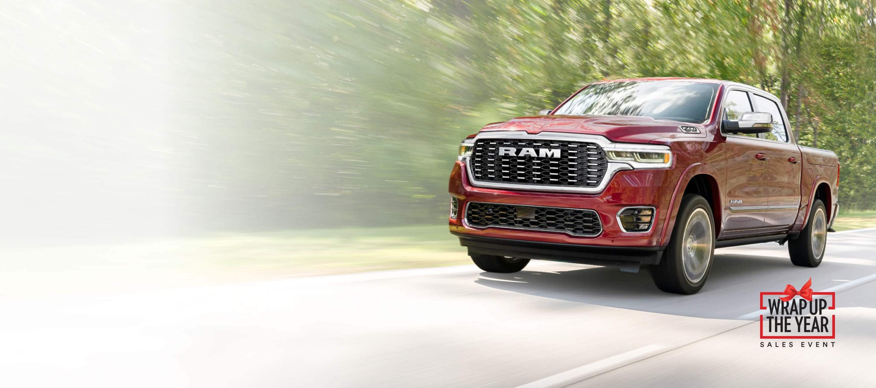 A red 2025 Ram Tungsten traveling down a highway with the background blurred. Wrap Up The Year Sales Event.