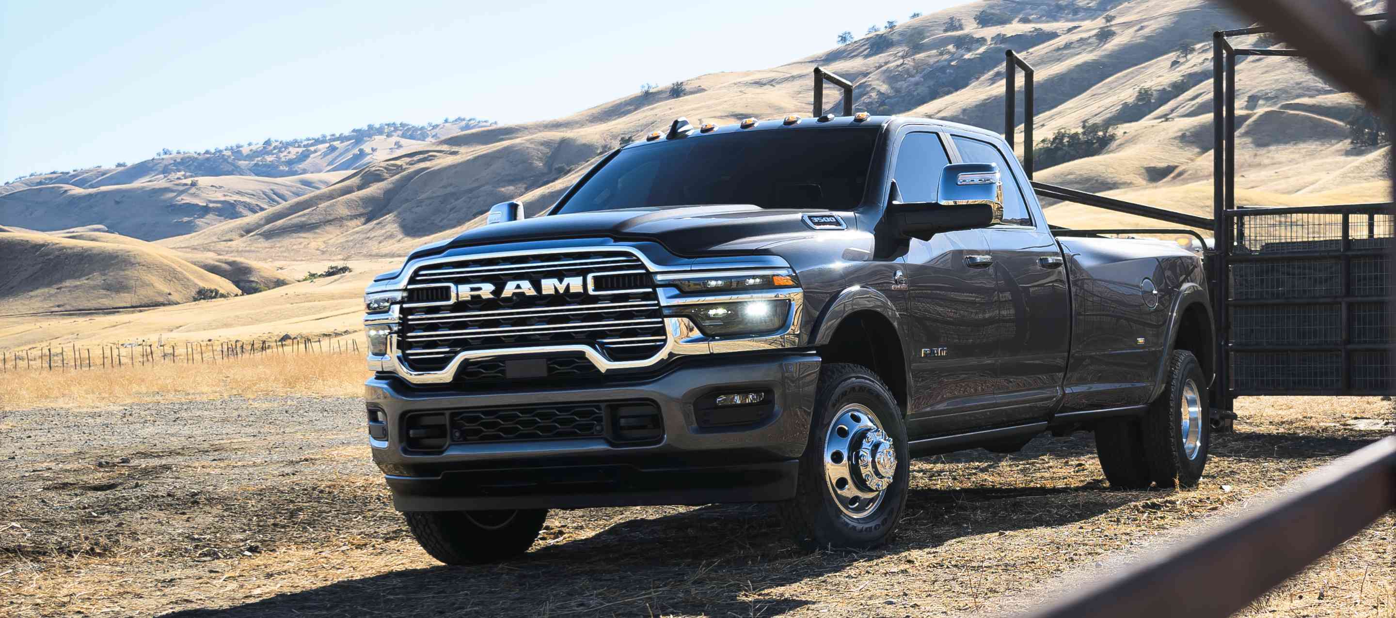 A gray Ram 3500 Limited Longhorn Crew Cab parked at a cattle ranch in the desert.