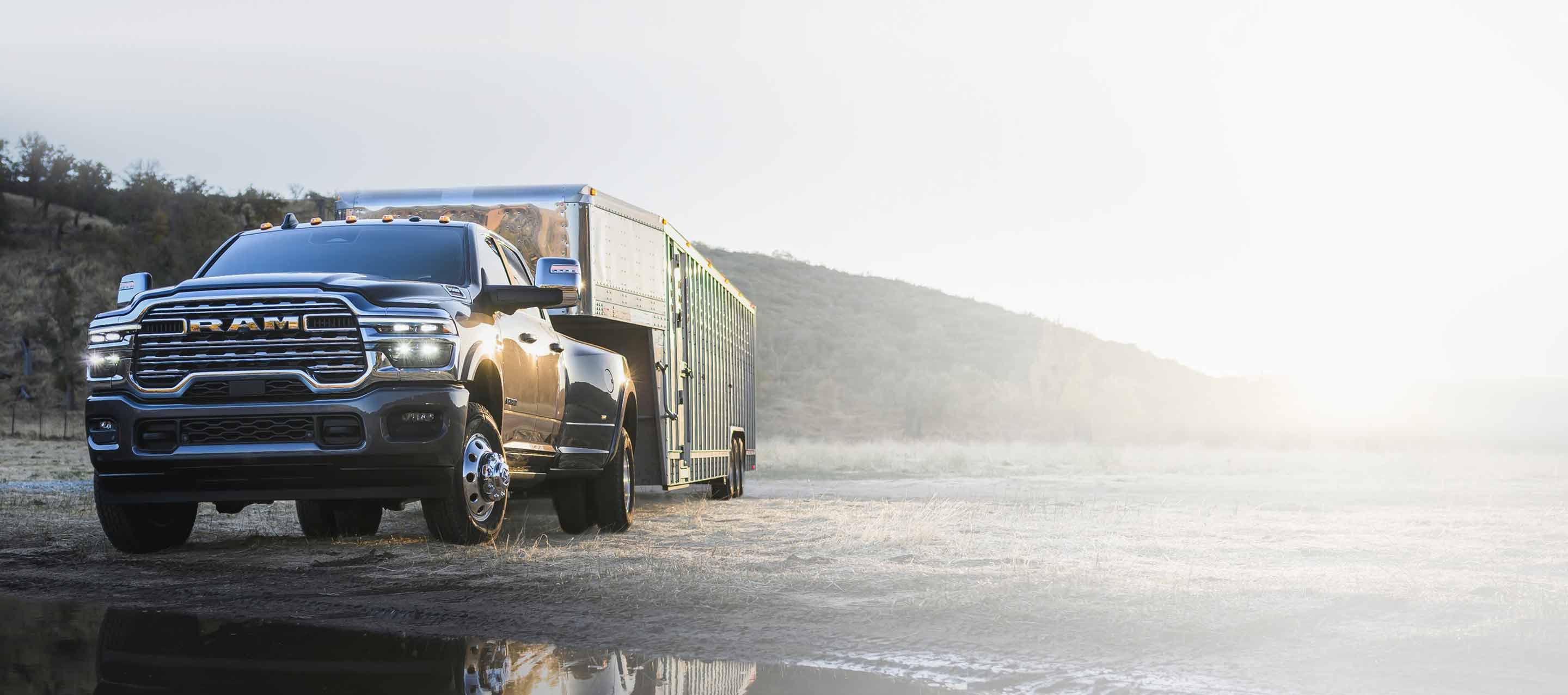 A red 2025 Ram 3500 Laramie 4x4 Crew Cab towing an enclosed box.