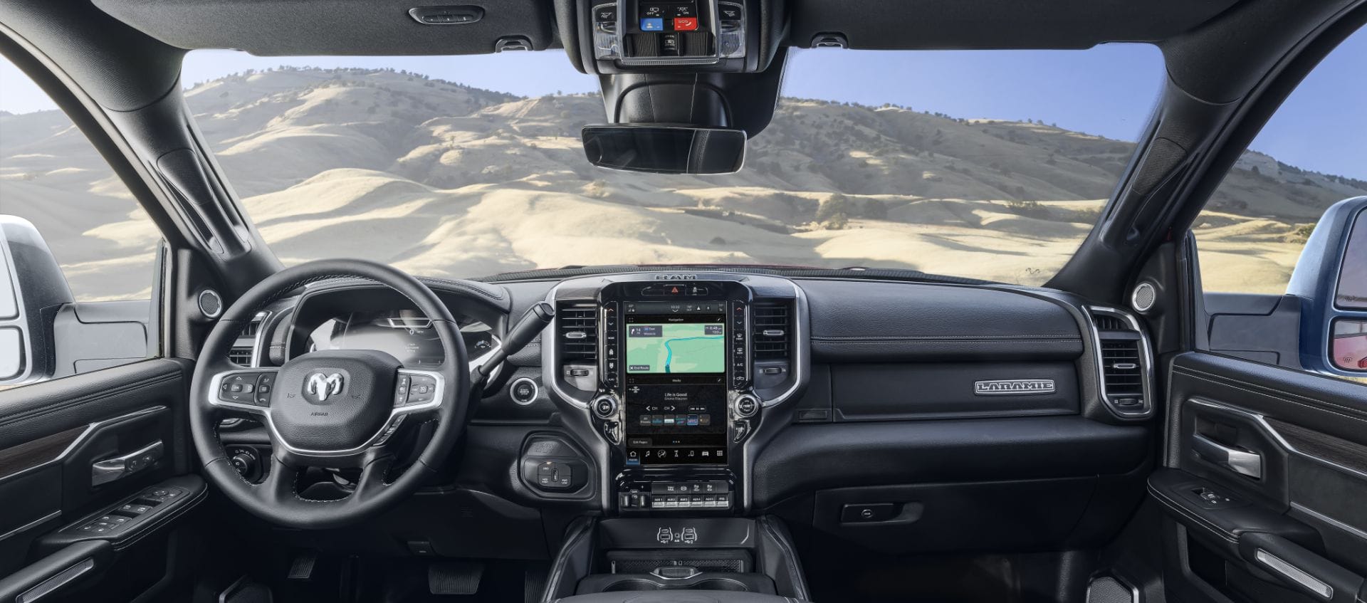 The interior of a 2025 Ram 5500 Laramie Chassis Cab from the driver's perspective, demonstrating through the windshield that the truck is in the desert.