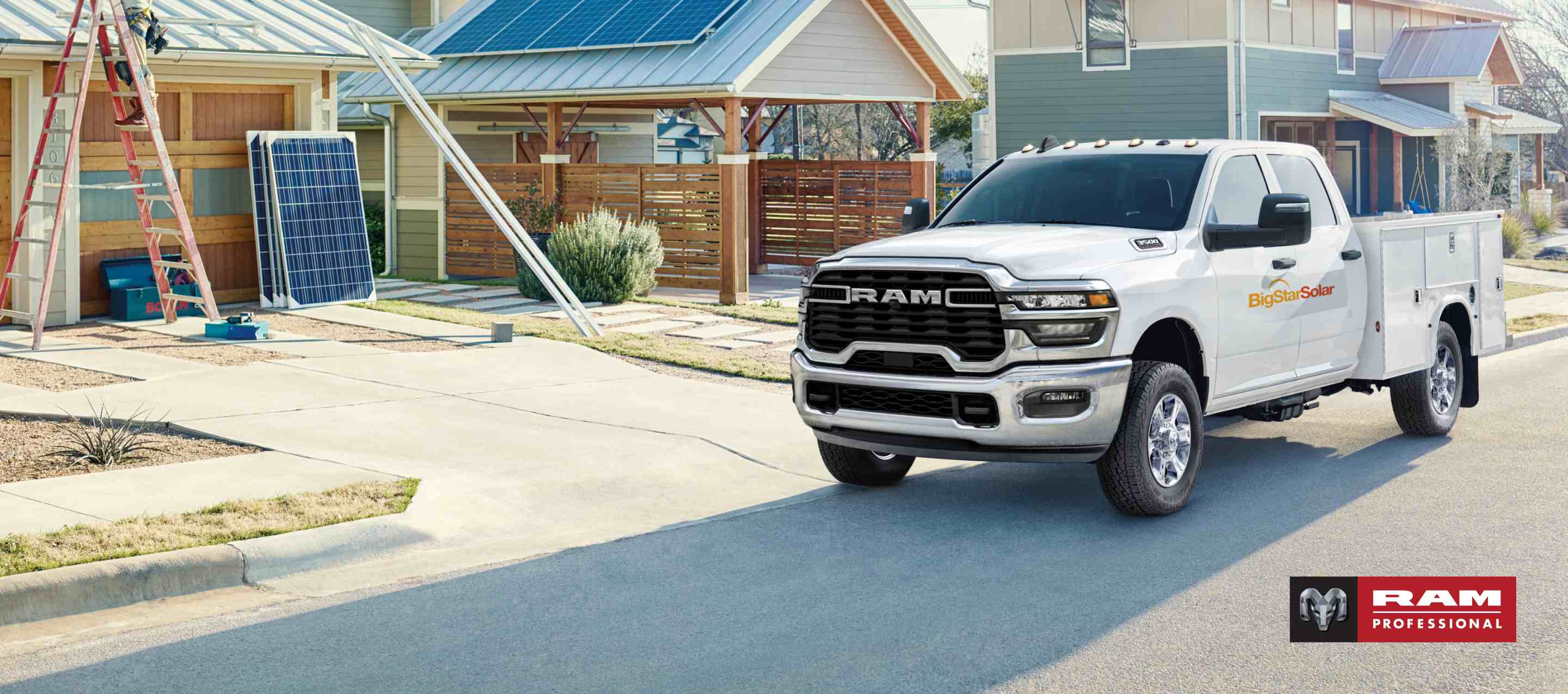 A white 2025 Ram 3500 Tradesman Crew Cab Chassis Cab with the Chrome Appearance Package and a solar company logo on its driver side, parked in front of a home with solar panels on the garage roof. Ram Professional.