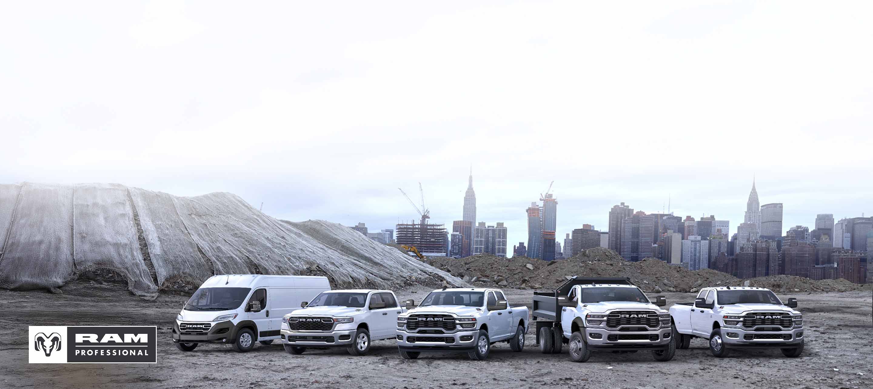 The 2026 Ram Brand lineup in white: a Ram ProMaster 3500 SLT Plus High Roof Cargo Van, a Ram 1500 Tradesman 4x4 Crew Cab, a Ram 2500 Tradesman 4x4 Crew Cab, a Ram 3500 Tradesman 4x2 Chassis Cab Regular Cab with dump body upfit and a Ram 3500 Tradesman 4x4 Crew Cab—all parked side-by-side at a pre-construction site, with a cityscape in the background.