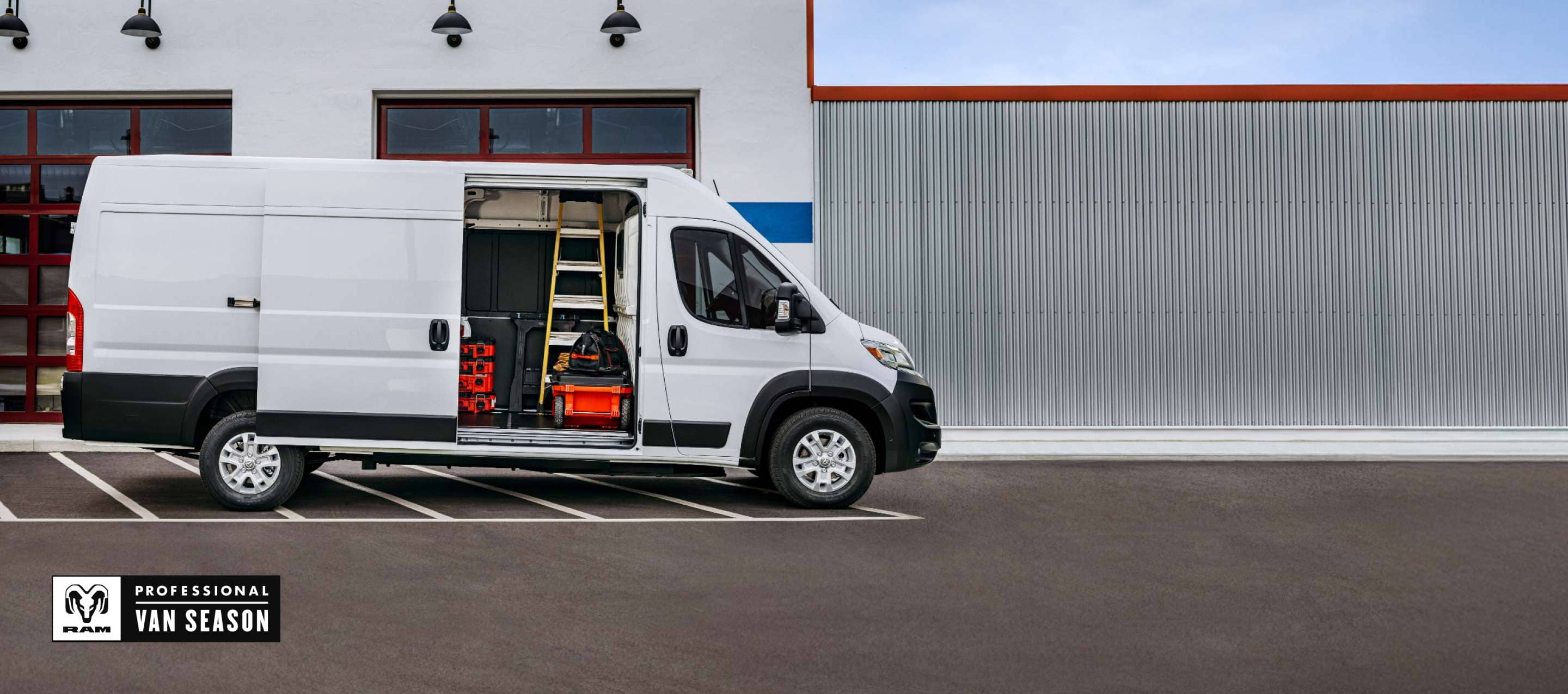 A white 2025 Ram ProMaster EV 3500 SLT High Roof Cargo Van with its passenger-side sliding door and rear doors open, revealing crates on shelves. Ram Professional Van Season.