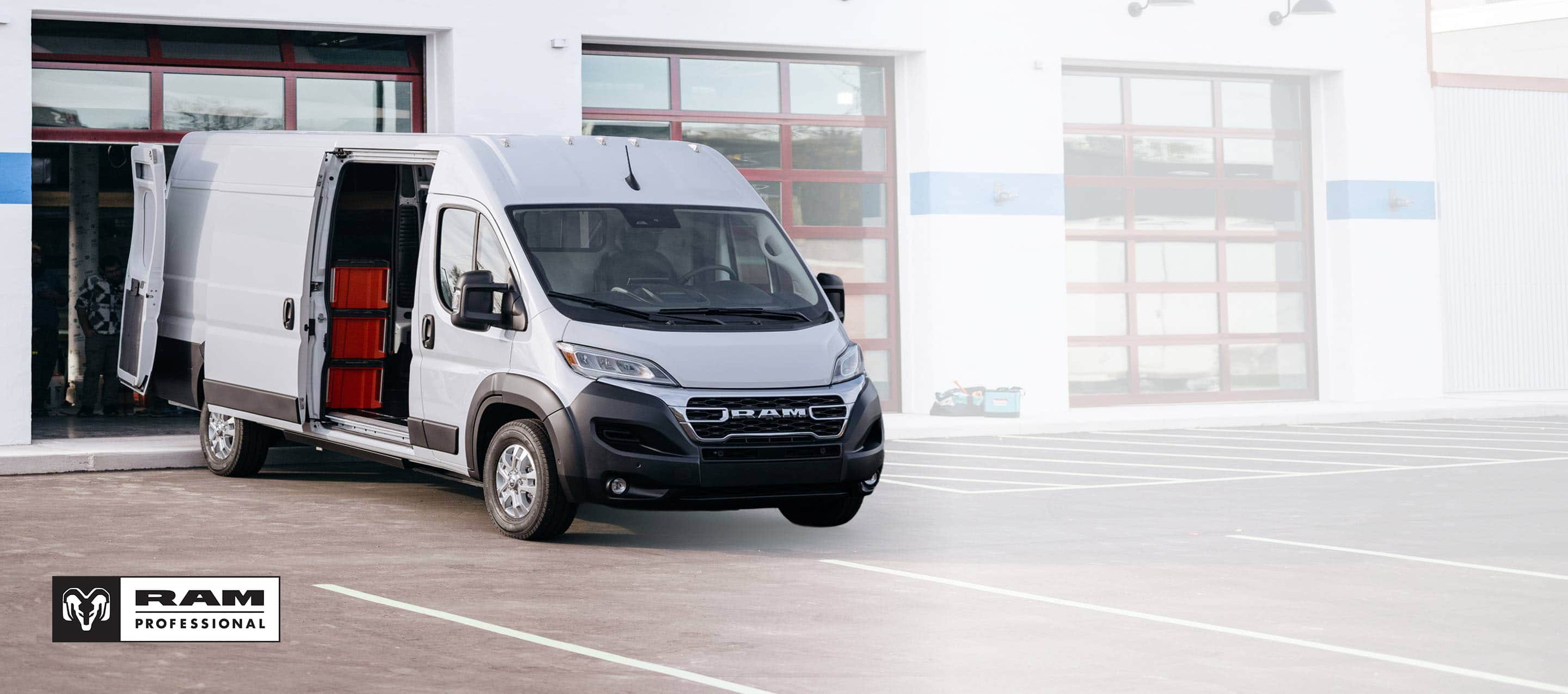 A white 2025 Ram ProMaster EV 3500 SLT Plus High Roof Cargo Van with its passenger-side sliding door and rear doors open, revealing crates on shelves. Ram Professional.