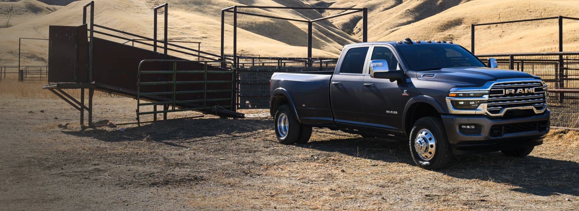 A black 2026 Ram 3500 Limited Longhorn 4x4 Crew Cab parked at a cattle ranch in the desert.