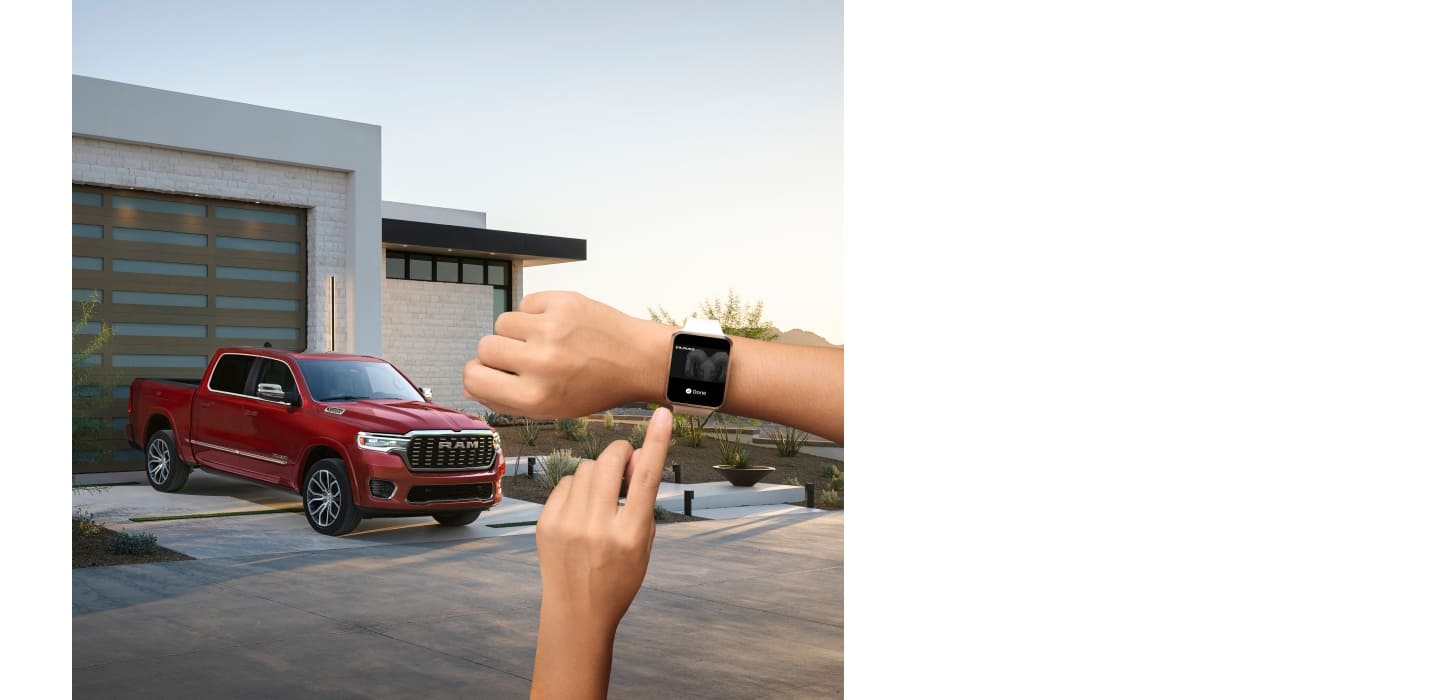 Person operating their smartwatch in the foreground with a red 2026 Ram 1500 Tungsten 4x4 Crew Cab in the background.