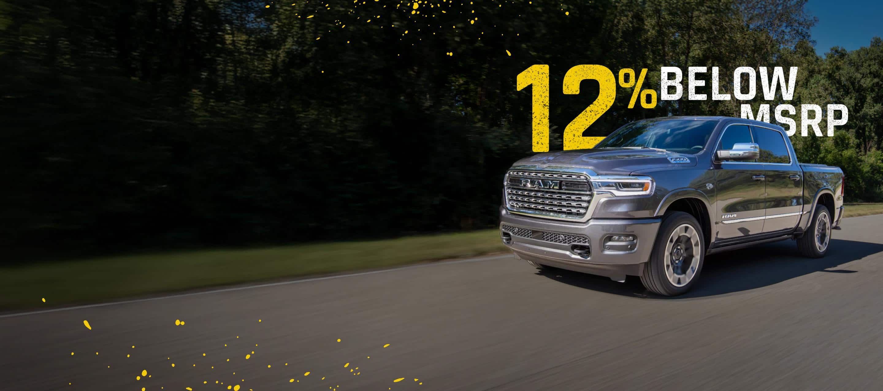 A gray 2026 Ram 1500 Limited 4x4 Crew Cab traveling down a country road. 