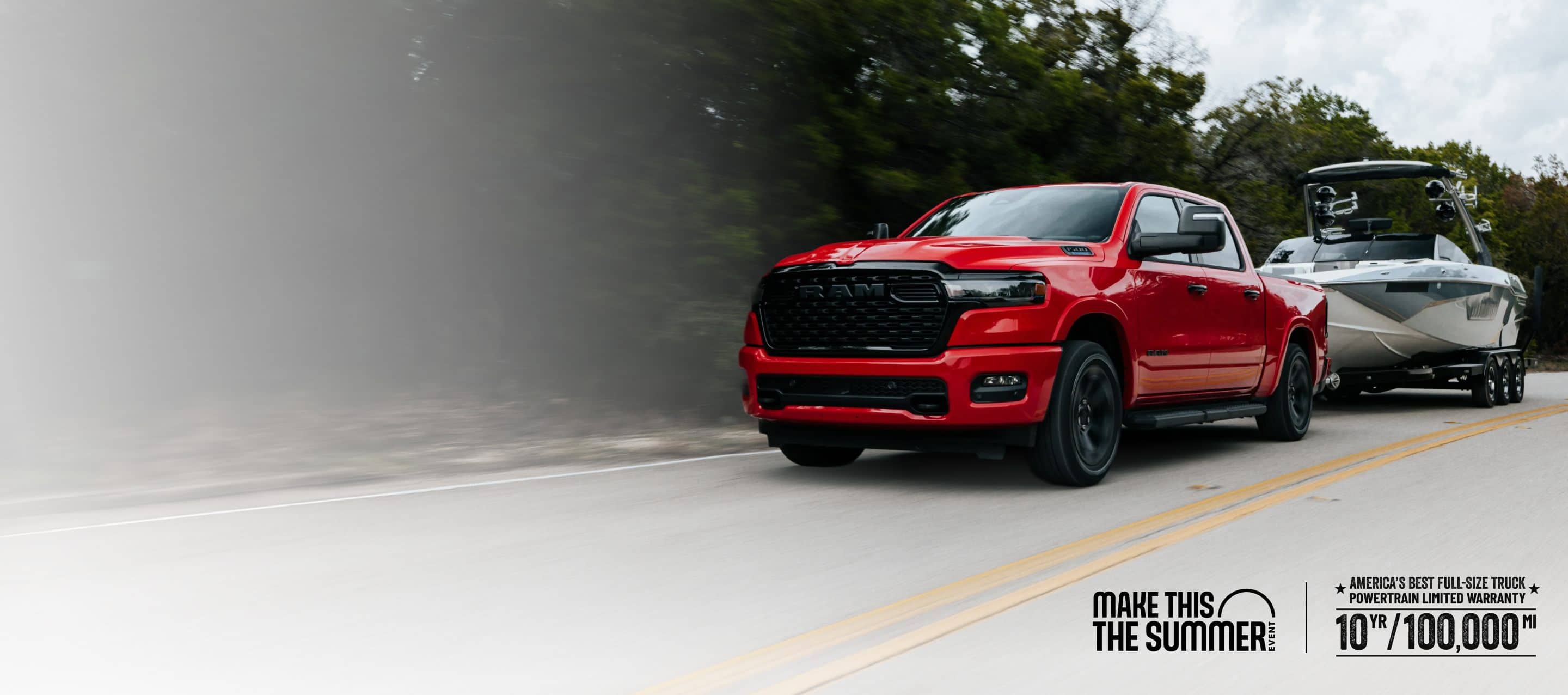 A red 2026 Ram 1500 Big Horn 4x4 Crew Cab pickup traveling down a highway, towing a motorboat. Limited Warranty—10 Years/100,000 Miles. Make This The Summer.