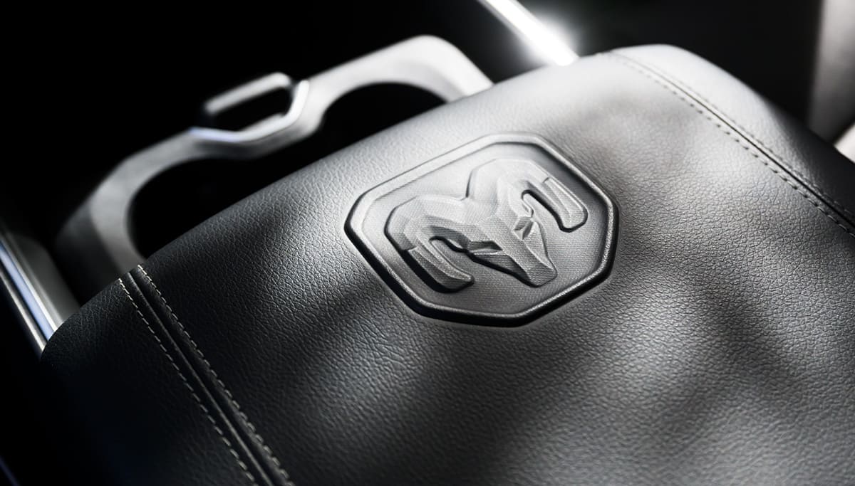 Display The padded center console armrest with ram's head in the 2026 Ram 2500.
