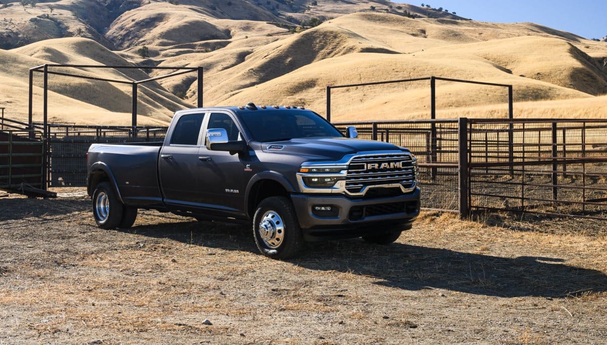 Display A black 2026 Ram 3500 Limited Longhorn Crew Cab parked at a cattle ranch in the desert.
