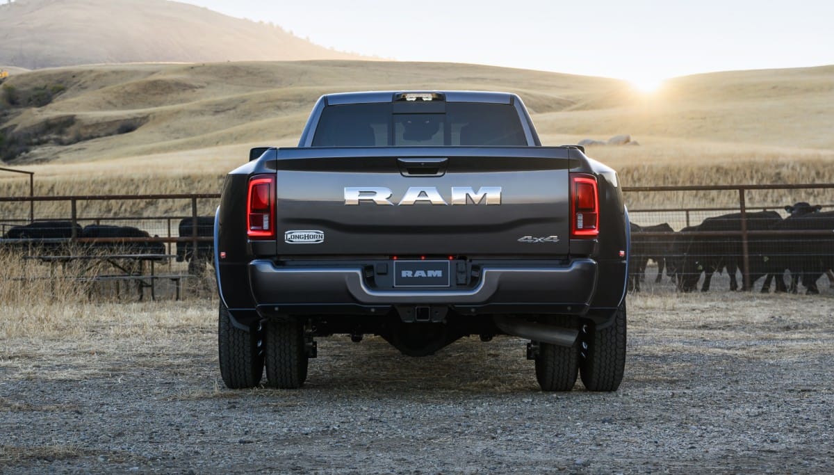 Display The rear angle of a black 2026 Ram 3500 Limited Longhorn 4x4 Crew Cab parked at a cattle ranch.