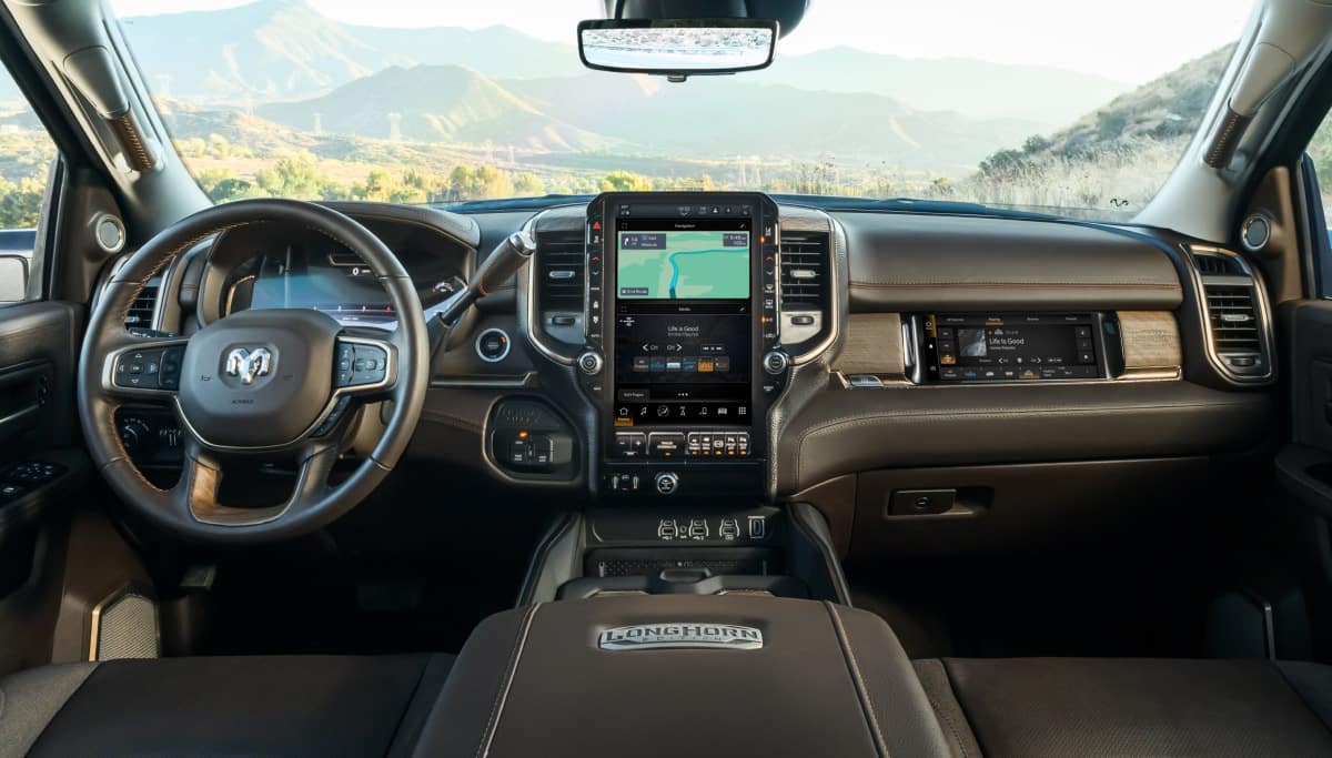 Display The front seat area in the 2026 Ram 3500 Limited Longhorn focusing on the steering wheel, Uconnect touchscreen and Front Passenger Interactive Display.