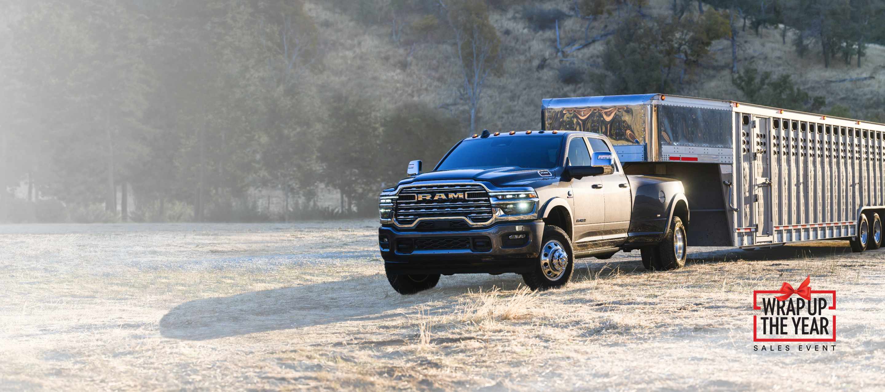 A gray 2026 Ram 3500 Limited Longhorn 4x4 Crew Cab towing a large fifth-wheel livestock trailer. Wrap Up The Year Sales Event.