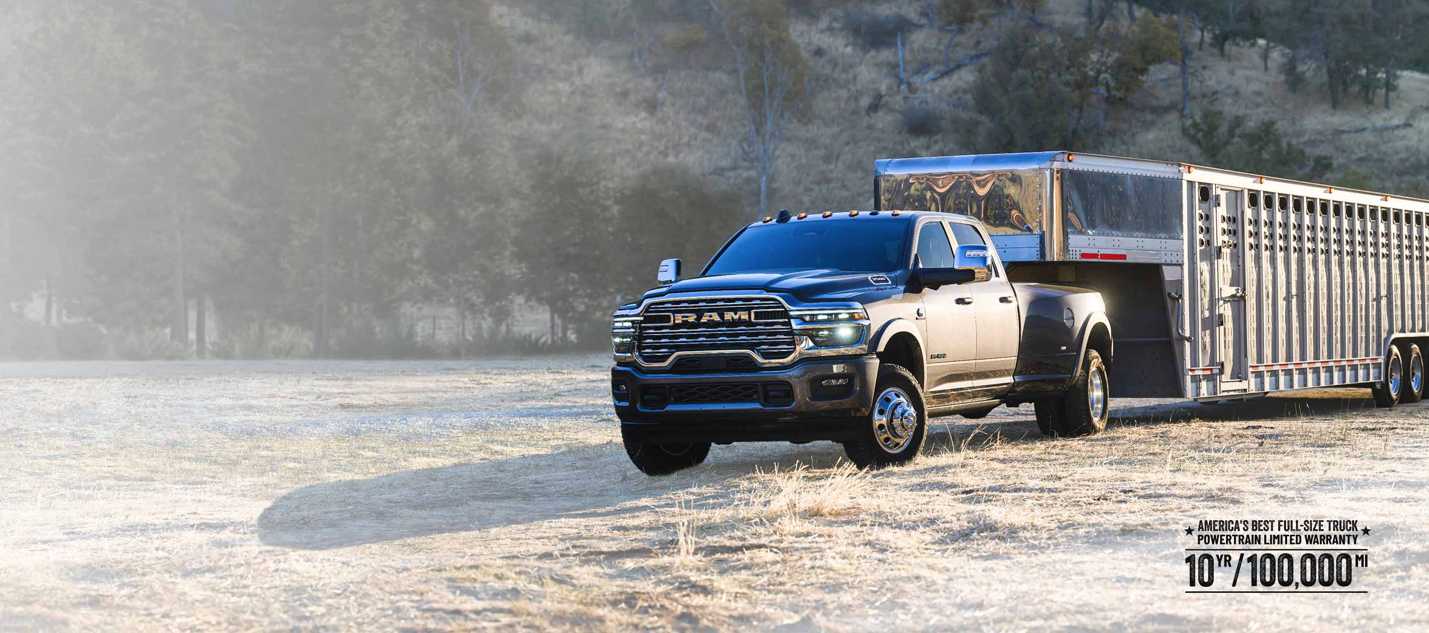 A gray 2026 Ram 3500 Limited Longhorn 4x4 Crew Cab towing a large fifth-wheel livestock trailer as it travels off-road. Wrap Up The Year Sales Event.