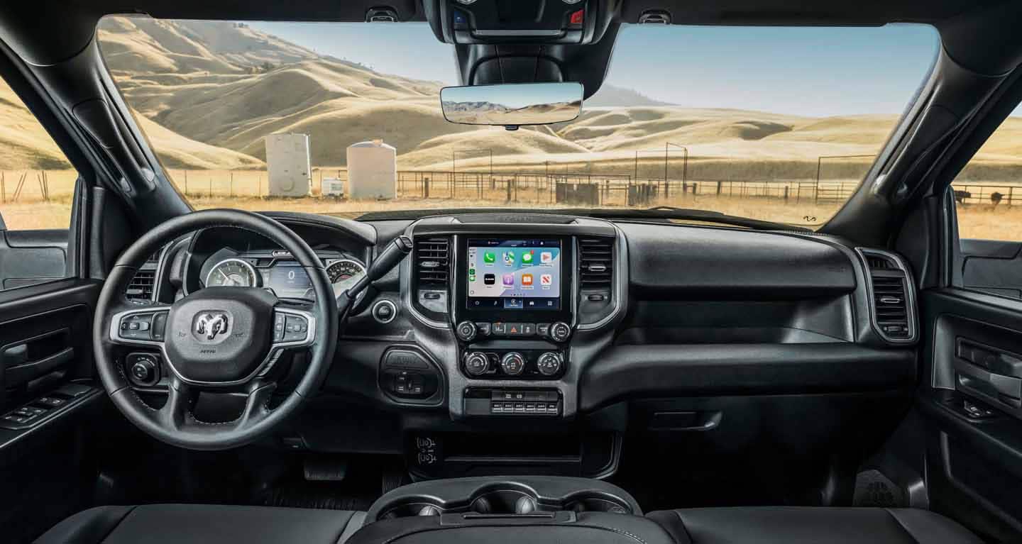 Display The front seat area of a 2026 Ram Tradesman Chassis Cab focusing on the steering wheel, Digital Cluster Display, Uconnect touchscreen and center stack controls.