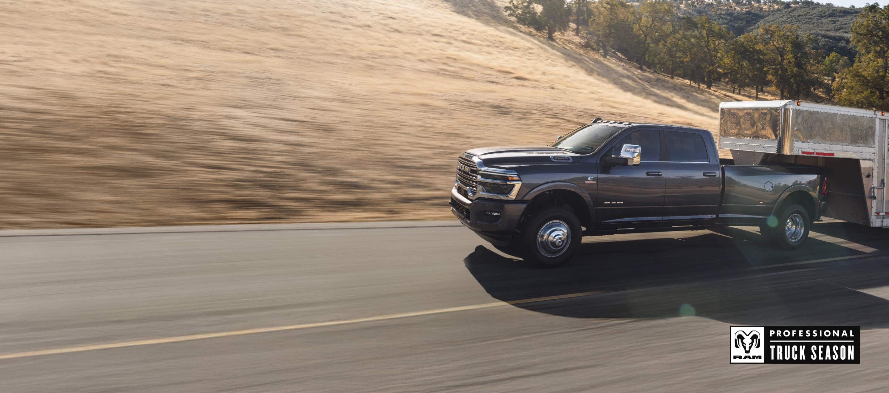 A 2026 Ram 3500 Limited Longhorn 4x4 Crew Cab towing a large fifth-wheel livestock trailer and a black 2026 Ram 2500 Rebel 4x4 Crew Cab parked near each other. Ram Professional Truck Season.