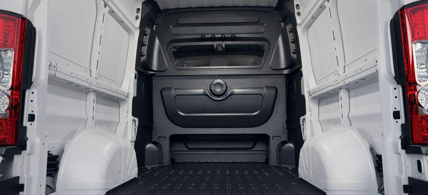 Display The rear of the 2026 Ram ProMaster Crew Van Cargo Van High Roof displaying the large cargo area and the partition between the rear seats and cargo area.