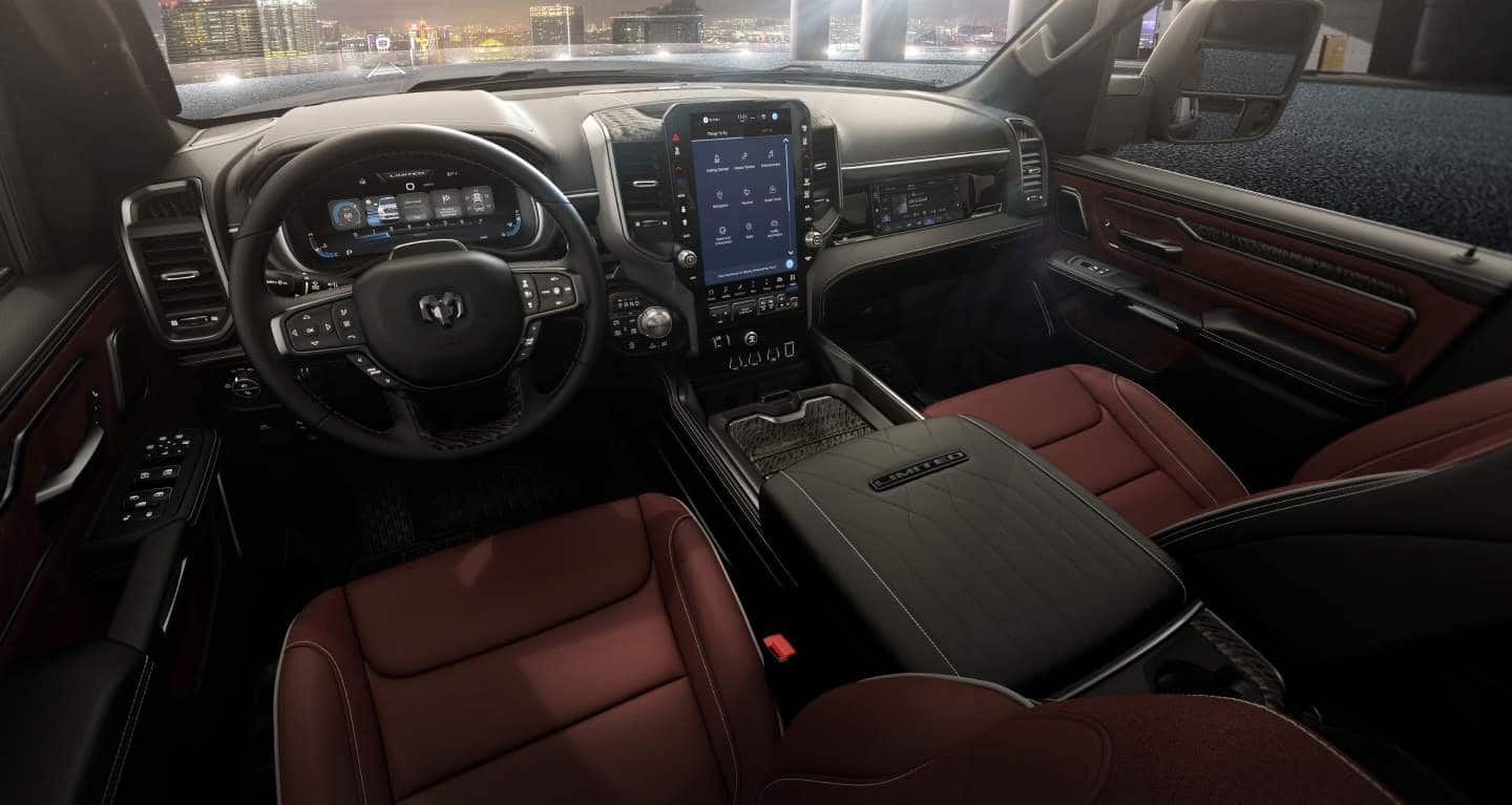 The front row of a 2027 Ram 1500 Limited 4x4 Crew Cab with red bucket seats and a Digital Cluster Display