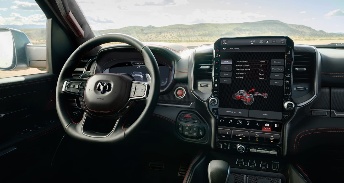 Display The interior of the 2027 Ram 1500 TRX SRT, focusing on the steering wheel, Digital Cluster, Uconnect touchscreen and center stack controls, with the Sport Drive Mode page displayed on the touchscreen.