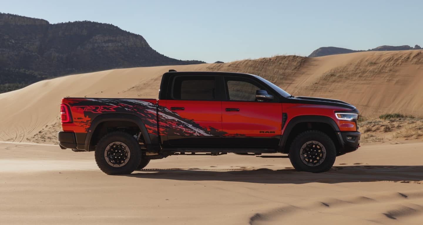 Display A red 2027 Ram 1500 TRX SRT Bloodshot Night Edition with a black hood and roof and special bedside splash graphic.
