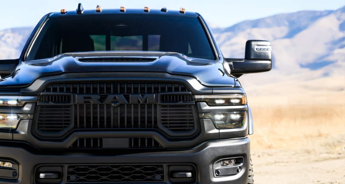 Close-up of the 2027 Ram 2500 front grille and headlights in a desert setting