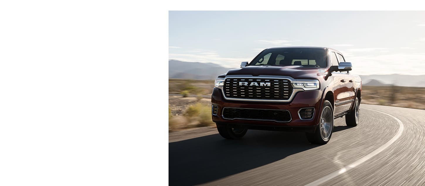 A red 2025 Ram Tungsten Crew Cab traveling down a winding highway.