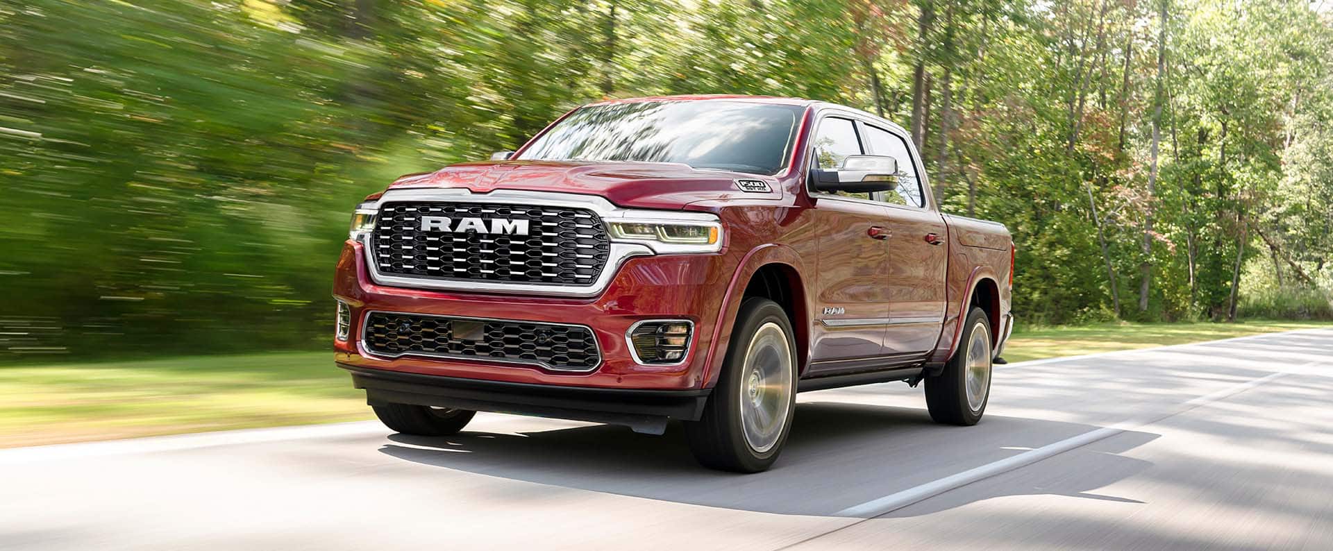 A red 2025 Ram Tungsten Crew Cab traveling down a highway.