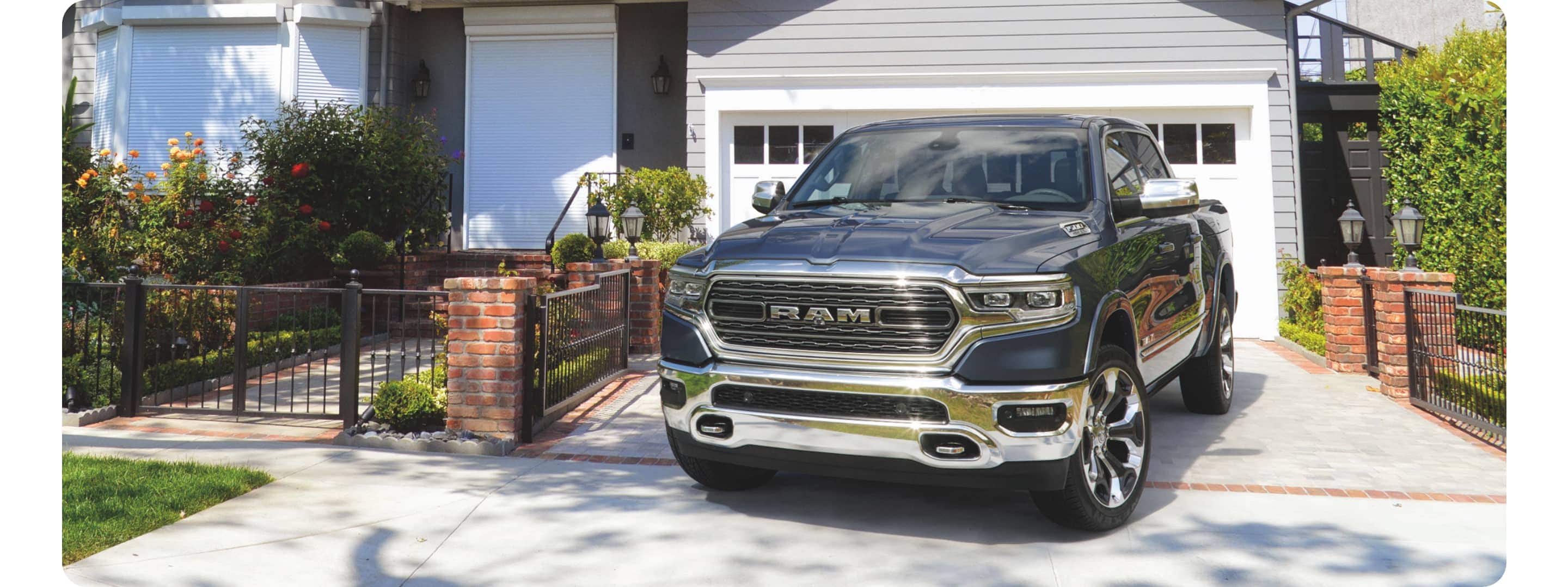 A 2021 Ram 1500 Limited parked in the driveway of a contemporary home.