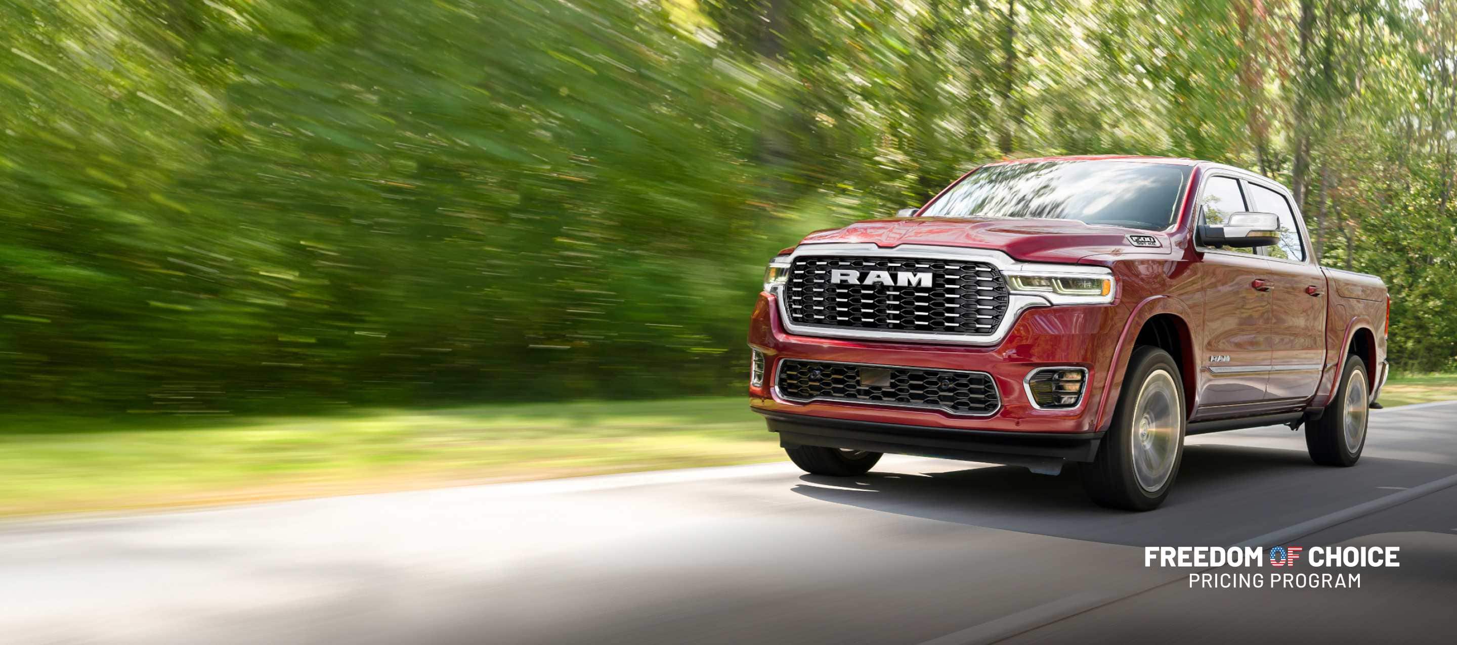 A red 2025 Ram Tungsten traveling down a highway with the background blurred. Truck Month. Freedom Of Choice Pricing Update Sales Event.
