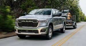 The Ram 1500 towing a motorboat on an open road.