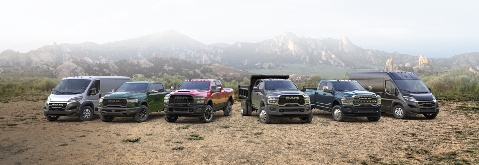 The 2026 Ram lineup: a white Ram ProMaster 2500 SLT Standard Roof Cargo Van, a green Ram 1500 Rebel 4x4 Crew Cab, a red Ram 2500 Rebel 4x4 Crew Cab, a gray Ram 4500 Big Horn Chassis Cab Crew Cab with dump body upfit, a blue Ram 3500 Limited 4x4 Crew Cab and a black Ram ProMaster 3500 SLT Plus High Roof Cargo Van, all parked side-by-side on a hilltop.