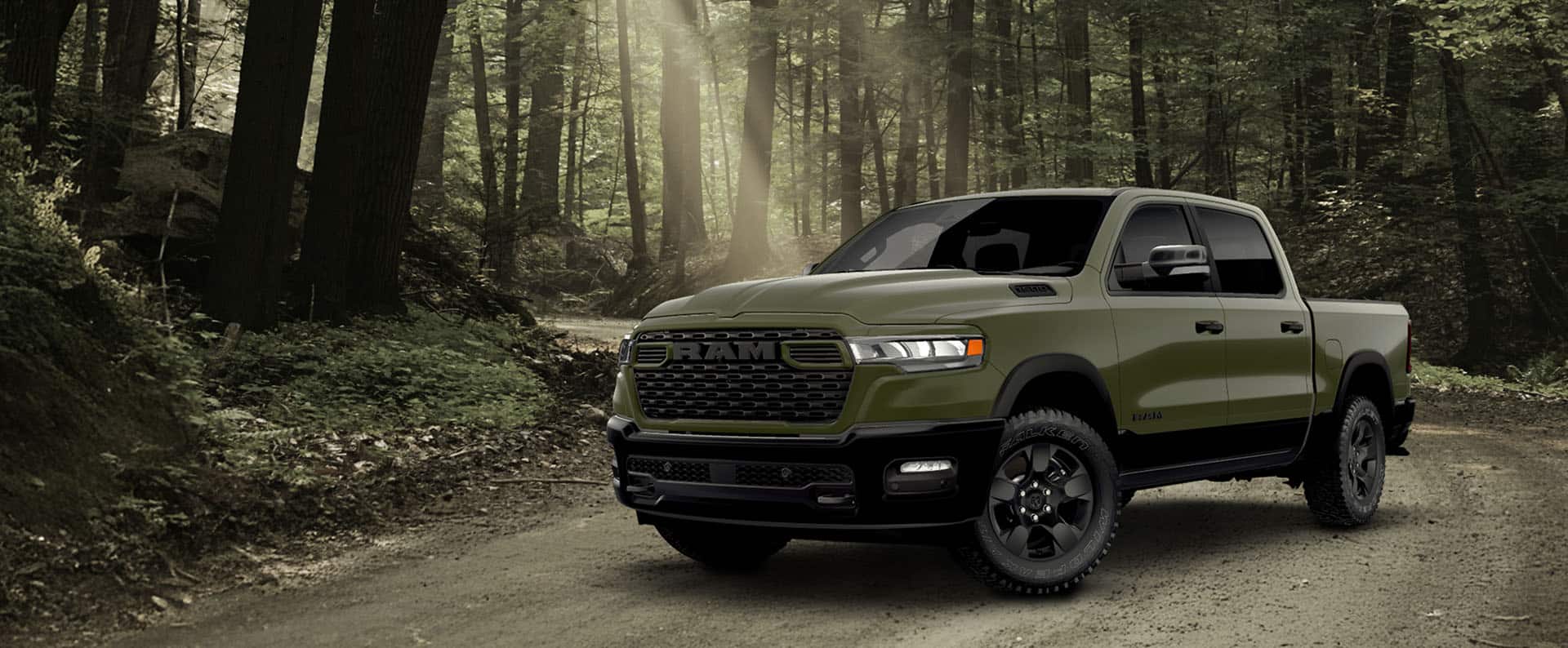 An olive green Ram 1500 BackCountry 4x4 Crew Cab pickup on a dirt road in the woods.
