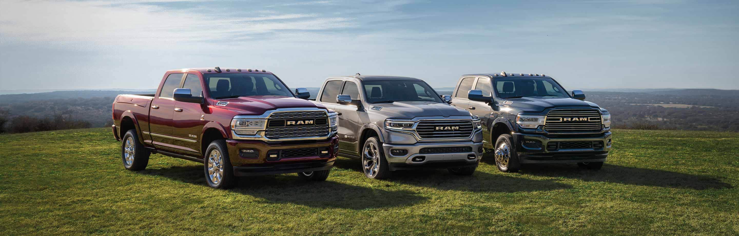 Three 2022 Ram trucks, a 2500 Limited, 1500 Limited Longhorn and 3500 Laramie, parked in an open field.