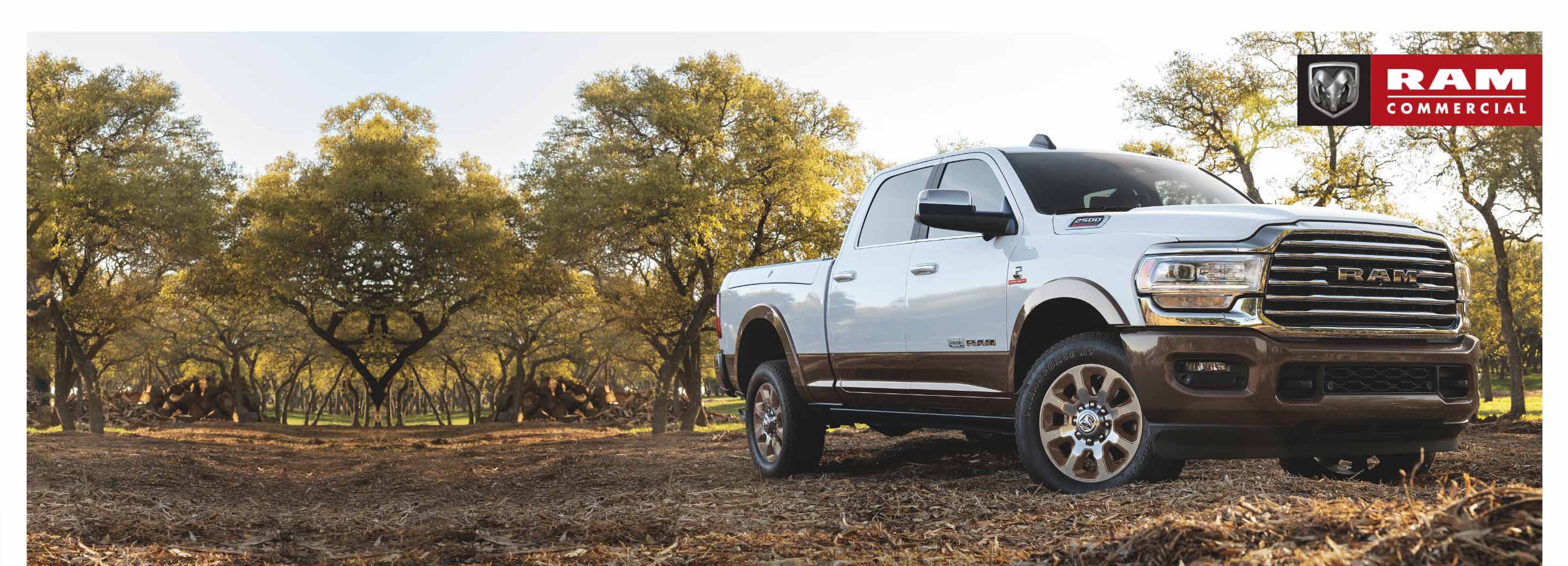 A 2021 Ram 2500 Limited Longhorn 4x4 parked in an orchard. The Ram Commercial logo.