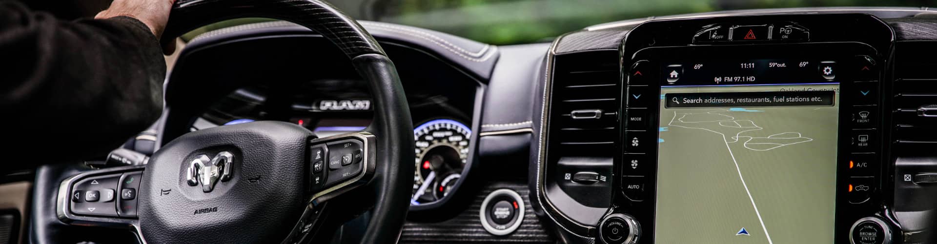 The interior of the 2021 Ram 1500 Limited, focusing on the steering wheel and 12-inch Uconnect touchscreen.
