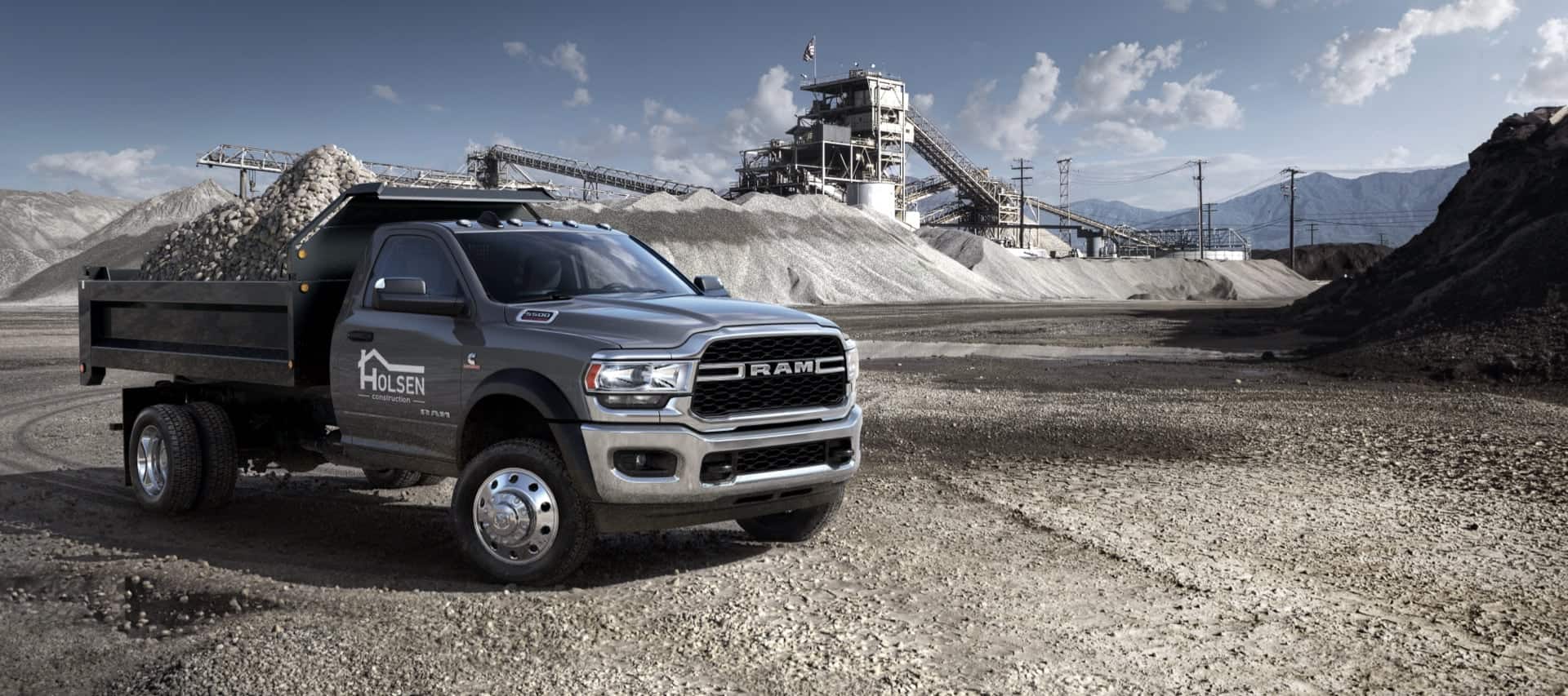 The 2021 Ram 5500 Chassis Cab with a truck bed upfit allowing it to carry a large pile of gravel.