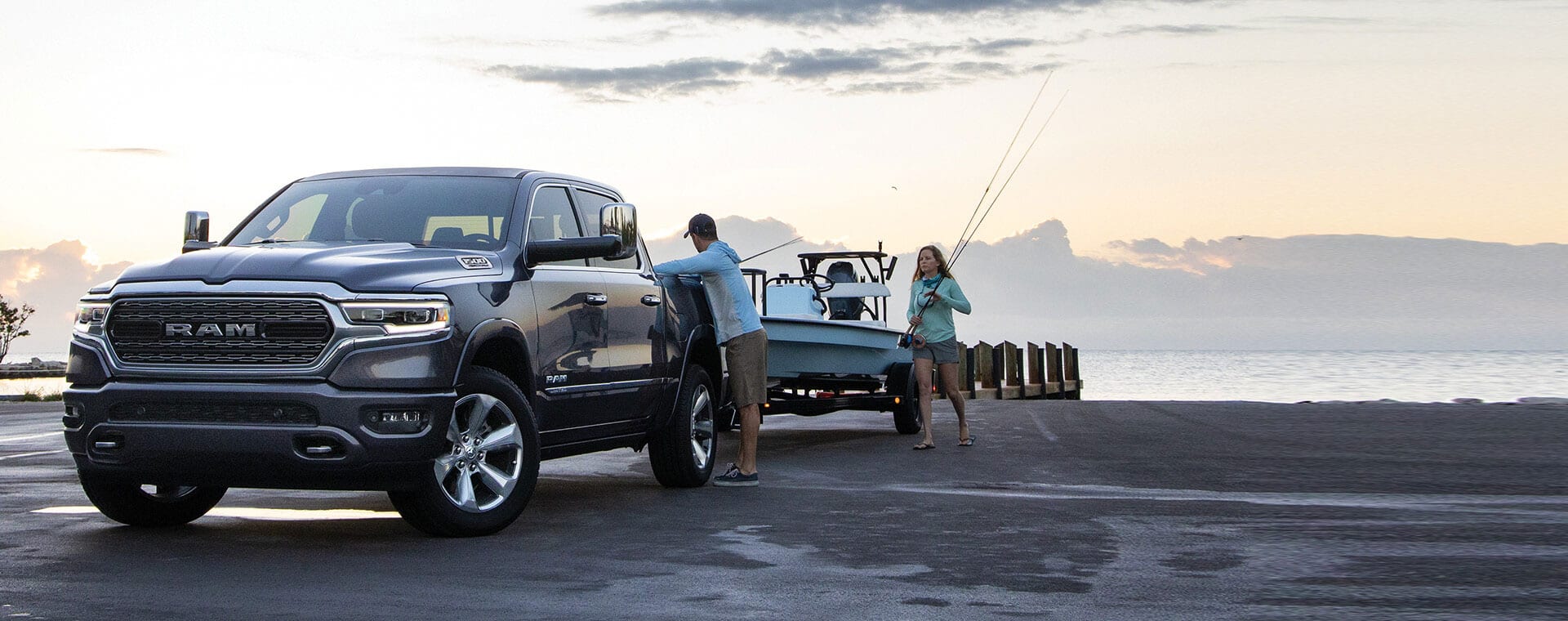 A 2021 Ram 1500 Limited parked on the beach with a boat attached to the tow hitch.