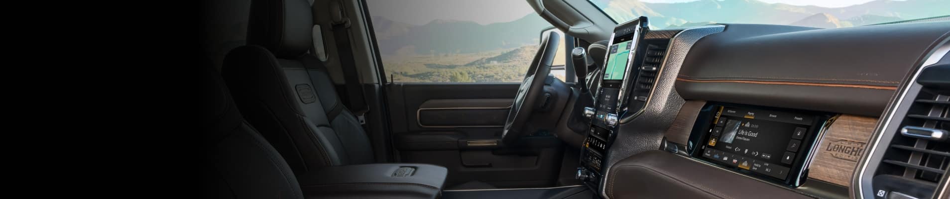 The steering wheel, Uconnect touchscreen and Front Passenger Interactive Display in the 2026 Ram 2500 Limited Longhorn.