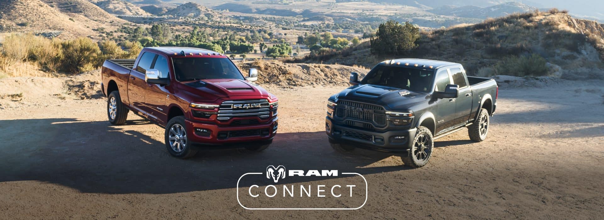 A red 2026 Ram 2500 Laramie Crew Cab and a gray 2026 Ram 2500 Rebel Crew Cab parked perpendicular to each other on a clearing in the mountains. The Ram Connect logo.